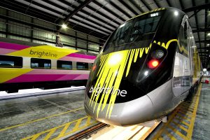 The Brightline commuter train features bright yellow and pink designs.